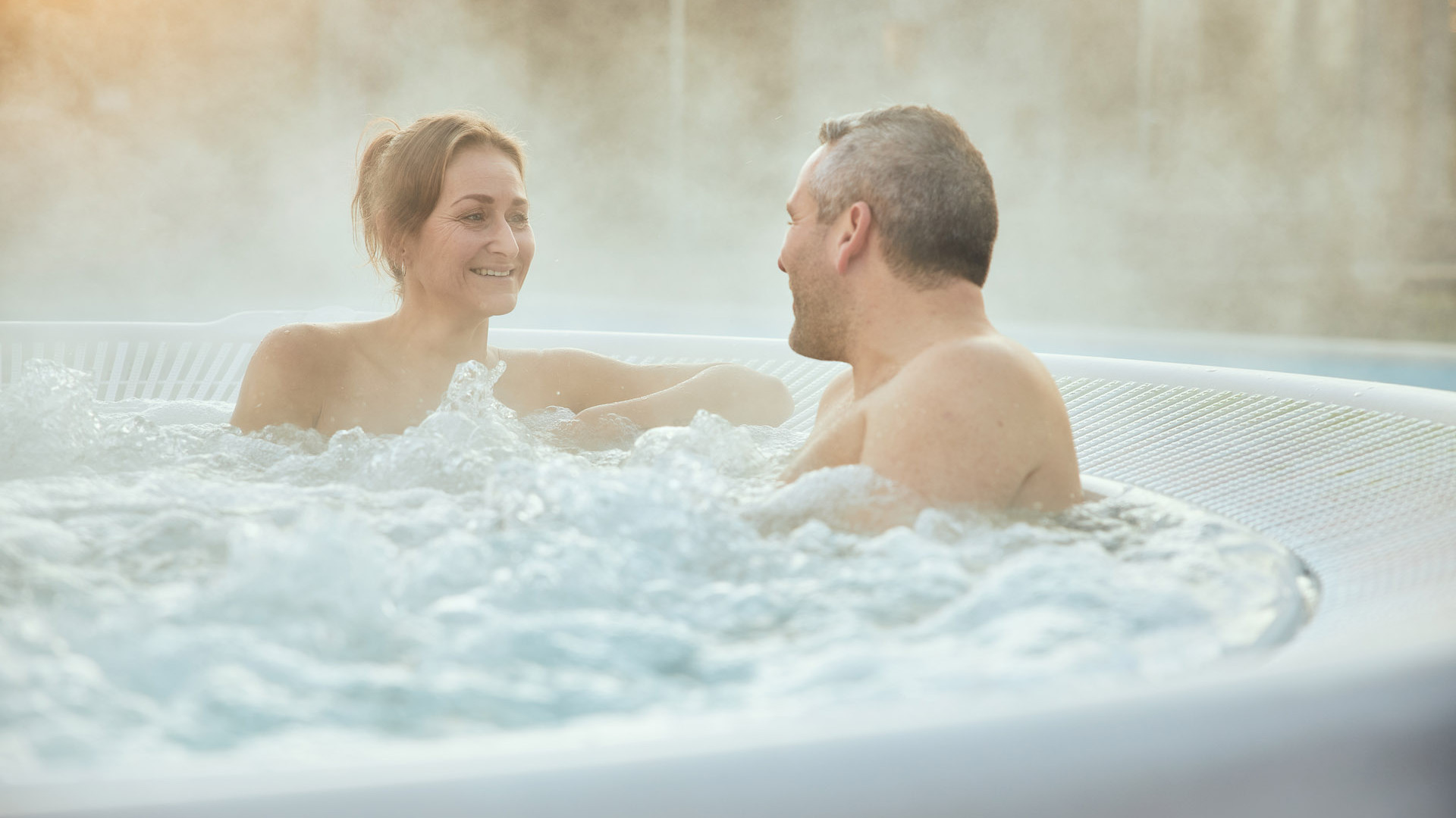Een koppel zit buiten in een whirlpool 